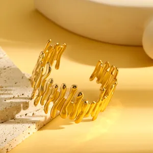 Macro-opname van de onregelmatige goudkleurige smeltextuur op een stalen armband