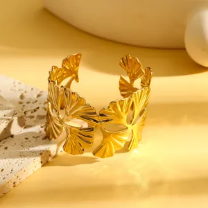 Detail van vintage goudkleurige opengewerkte ginkgoblad manchetarmband met textuur