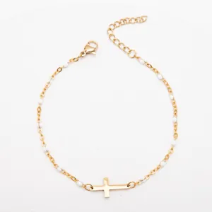 Vue détaillée d'un bracelet croix en acier inoxydable plaqué or 18K avec perles émail