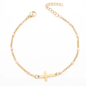 Vue détaillée d'un bracelet croix en acier inoxydable plaqué or 18 carats avec perles