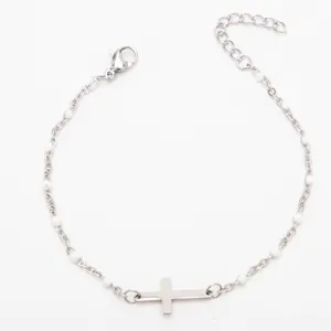 Vue détaillée d'un bracelet en acier titane avec perles en émail blanc et croix