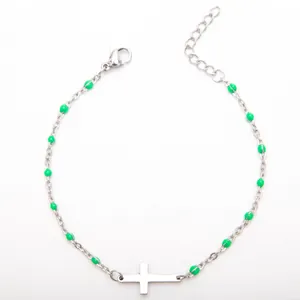 Gros plan d'un bracelet en acier inoxydable avec perles en émail vert et croix