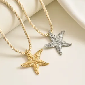Dettaglio dei ciondoli a stella marina oro e argento con cordino in corda intrecciata chic