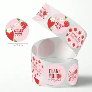 Macro detail of one inch round strawberry Thank You adhesive stickers roll for baking