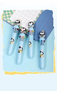 Gros plan de stylos à bille 10 couleurs avec figurines de pingouins sur fond bleu