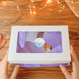 Close-up of holographic Thank You sticker sealing a white gift box with purple paper.