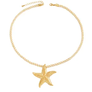 Elegante collana con ciondolo a stella marina dorata con cordino intrecciato panna per la spiaggia.