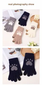Gros plan de gants en tricot pelucheux avec motif de pattes mignon et doigts tactiles.