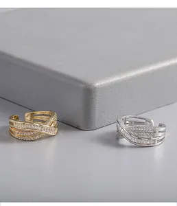 Close-up of gold and silver plated crisscross rings with brilliant paved zircons.
