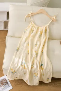 Close-up detail of a soft floral cotton gauze slip nightdress hanging on a wooden hanger