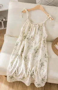 Detail view of floral cotton gauze camisole nightdress on a hanger in a cozy setting