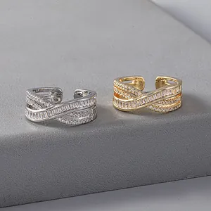 Elegant criss-cross open ring with shimmering cubic zirconia in gold and silver finish.