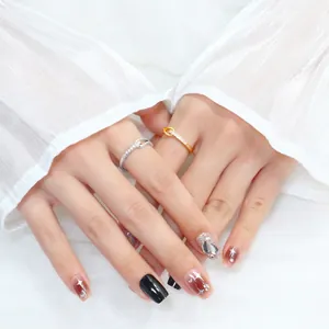 Close-up of silver and gold knotted rings with zircon stones on an Asian model's hand