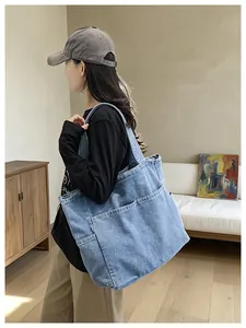 Lifestyle detail of a large Japanese denim shoulder bag shown worn by a female model in a room