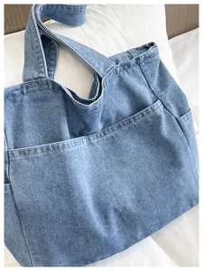Detailed close-up of the light blue denim fabric and stitching on a large tote bag