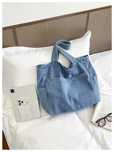 Large capacity casual blue denim tote bag on white bedding with iPad and sunglasses