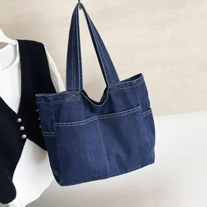 Minimalist navy blue denim tote bag with large capacity and front pockets for daily use