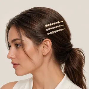Set of three elegant gold-toned bobby pins with sparkling rhinestones worn by a model