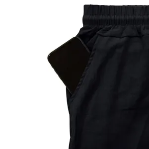 Close-up detail of black breathable cargo pants with large side pocket and elastic waist