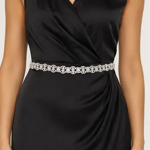 Elegant floral rhinestone belt close-up on a black satin evening dress for wedding.