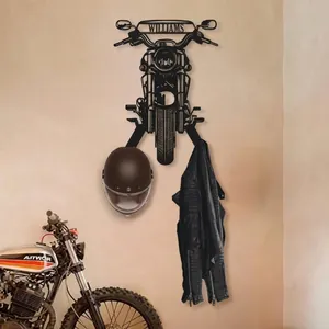 Dettaglio di un gancio da parete a forma di testa di moto vintage con casco e giacca.