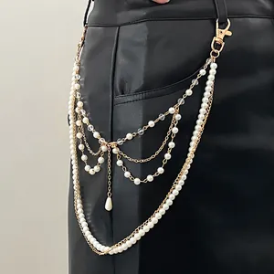 Dettaglio di una catena per pantaloni hip-hop multistrato con perle e catena oro