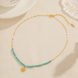 Vue détaillée du collier à perles turquoise avec pendentif soleil et marque dorée K18.