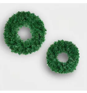 Detailed view of two lush green artificial PVC Christmas wreaths on a clean background
