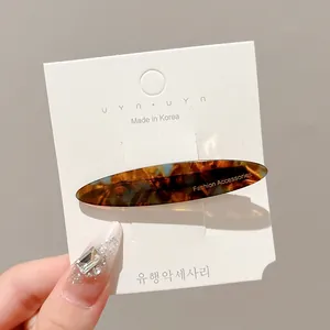Elegant Korean style tortoiseshell patterned oval hair clip displayed on a white card