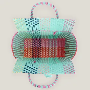 Top-down view of a handmade colorful woven plastic basket bag for beach and picnics