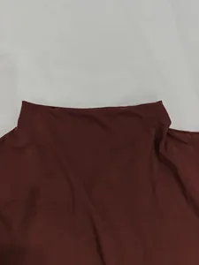 Macro detail view of maroon ribbed knit fabric texture on an elegant summer dress