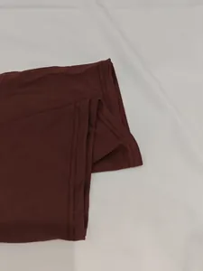 Detail view of the double-needle hemline stitching on a burgundy summer dress
