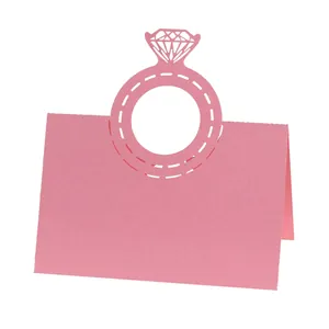 Macro view showing the intricate laser-cut diamond ring detail on pink wedding place card
