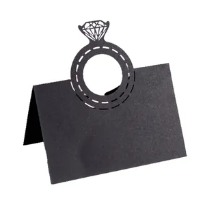 Detailed view of the black laser-cut diamond ring motif on a wedding table place card