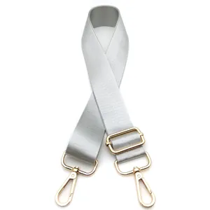 Detalle de correa ajustable de nailon plateado para bolso con mosquetones dorados