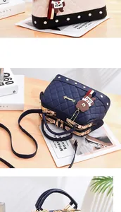 Detailed view of the quilted leather texture and gold hardware of a bowler bag with bear charm