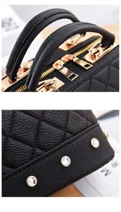 Detail shot of black quilted leather handbag with gold rivets and dual zippers