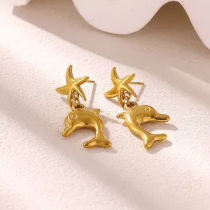 Close-up detail of golden stainless steel starfish and dolphin ocean style drop earrings
