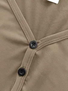 Gros plan sur le col en V et les boutons noirs d'une chemise décontractée kaki pour homme