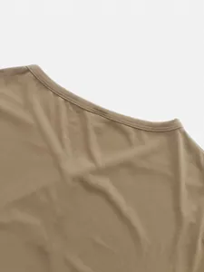 Gros plan sur l'encolure ronde et la texture respirante d'un t-shirt pour homme kaki.