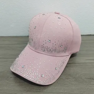 Close-up of a pink baseball cap decorated with sparkling rhinestone stars and small crystal dots.