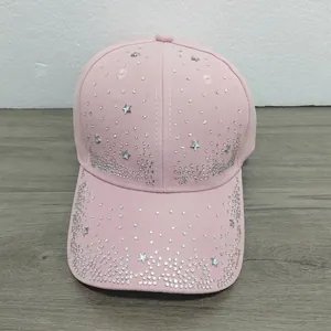 Detailed view of a pink baseball cap decorated with shiny rhinestone stars and dots.