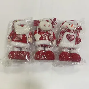 Detailed view of three packaged Christmas plush ornaments: Santa, Snowman, and Reindeer.