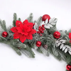 Detail van gevlokte kerstslinger met rode kerststerren en zilverkleurige bladeren.