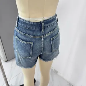 Detailed view of high-waisted denim shorts with frayed hems and distressed pockets
