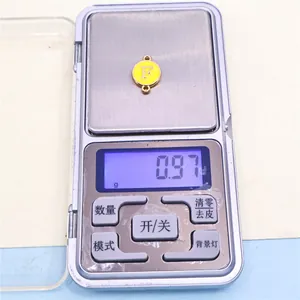 Báscula digital de precisión que muestra 0,97g de peso para este dije de letra F