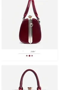 Close-up detail of a dark red glossy patent leather handbag with elegant gold clasp