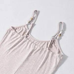 Détail de la robe caraco en maille montrant des bretelles avec des perles marbrées