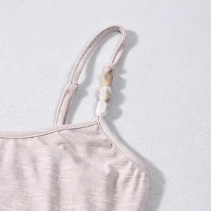 Détail de la bretelle d'une robe en maille avec perles décoratives marbrées