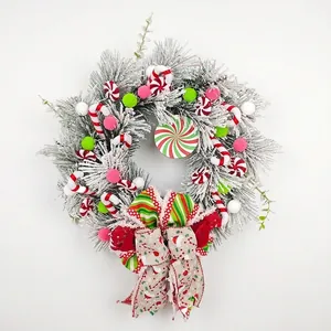 Flocked Christmas wreath decorated with candy canes and large festive bow ornament